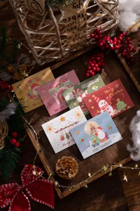Assorted festive Christmas greeting cards with Santa and snowman illustrations in a tray