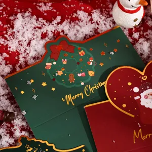 Close-up of green and red Christmas cards with gold stamped Merry Christmas text