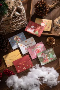 Variety of Christmas greeting cards with festive illustrations on a wooden table