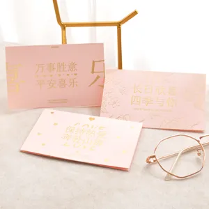 Gros plan de cartes de vœux roses avec lettrage élégant en feuille d'or et lunettes