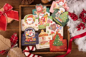 Assorted cute cartoon Christmas greeting cards with gold foil details in a festive setting