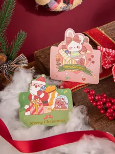 Detail of gold-foiled Christmas cards with cute Santa and rabbit illustrations.