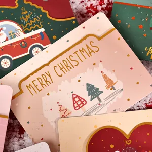 Close-up of gold foil Merry Christmas greeting cards with festive tree illustrations.
