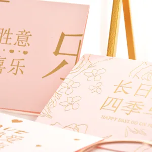 Détail d'une élégante carte de vœux rose avec gaufrage à la feuille d'or et motifs