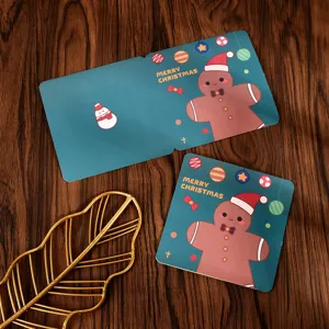 Close-up of square Christmas cards with cartoon gingerbread man and teal background