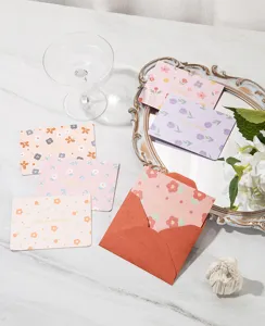 Cliché élégant de cartes de vœux à fleurs dorées avec une enveloppe rouge assortie
