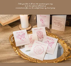 Vintage aesthetic greeting cards with floral and butterfly illustrations on a gold tray