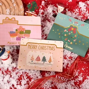 Close-up of creative Christmas greeting cards with gold foil patterns and festive props