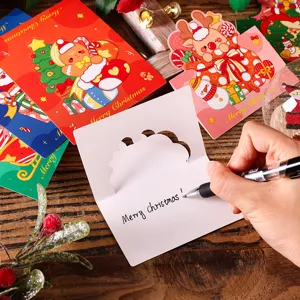 Handwriting a personalized holiday message on a festive cartoon Christmas greeting card set