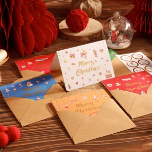 Vue détaillée de cartes de Noël assorties avec enveloppes en kraft sur une table en bois.
