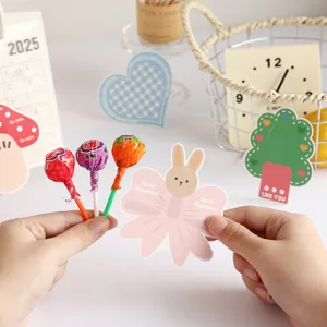 Macro view of a bunny-shaped pink lollipop decorative cardholder held in hands for student gifts