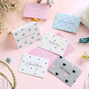 Detail showing a variety of minimalist pastel greeting cards with warm English sentiments.