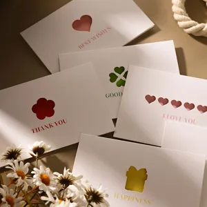 Detailansicht eleganter Grußkarten mit Ausstanzungen und buntem englischen Text auf Papier