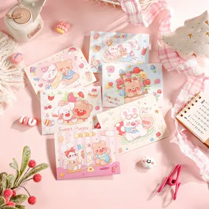 Detailed view of multiple cute cartoon folding greeting cards on a pink background.