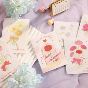 Primer plano de tarjetas de felicitación florales con rosas y mensajes románticos