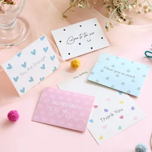 Detailed view of minimalist heart-patterned greeting cards with English blessings