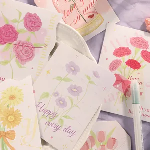 Primer plano de tarjetas de felicitación florales con texturas en tonos rosa y lila.