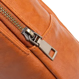 Primer plano de una cremallera de metal bronce vintage en un bolso bandolera de cuero marrón