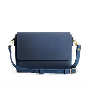 Detalle de un bolso bandolera azul de estilo minimalista y vintage para mujer