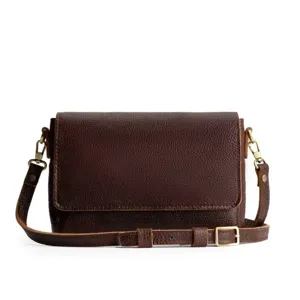 Detalle de un pequeño bolso bandolera vintage de cuero granulado marrón para mujer