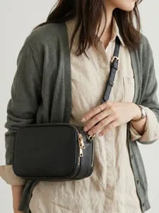 Elegante bolso bandolera de cuero granulado negro con cremalleras doradas dobles en modelo