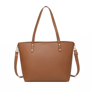 Bolso tote grande marrón de cuero granulado con correa ajustable y detalles de remaches.