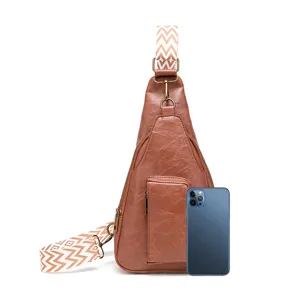 Bolso bandolera retro de cuero PU marrón con correa bordada junto a un smartphone