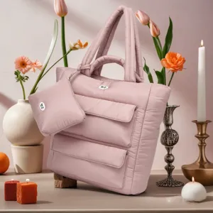 Detailweergave van een roze gewatteerde puffer tote tas met bijpassend tasje