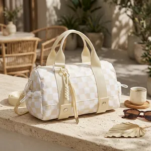 Borsa da viaggio capiente a scacchi con nappa intrecciata su tavolo in pietra