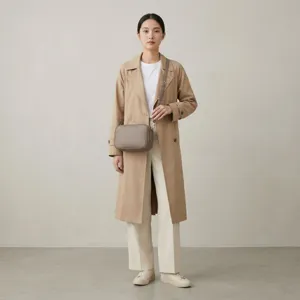 Modelo profesional luciendo un bolso bandolera de cuero topo de diseño minimalista