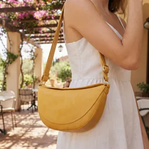 Vista detallada de un bolso de hombro vintage amarillo con forma de media luna