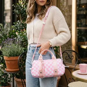 Borsa da viaggio a scacchi rosa e bianchi portata da una modella in un set all'aperto