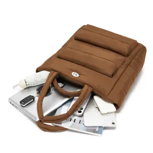 Gedetailleerd overzicht van bruine puffer tas met grote capaciteit voor laptop.