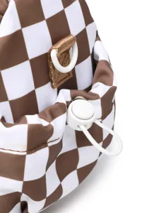 Close-up detail of checkered travel bag showing white drawstring toggle and D-ring buckle