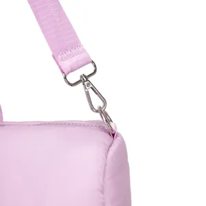 Detailopname van de zilveren metalen haak en riem van een lavendelkleurige gewatteerde tas.