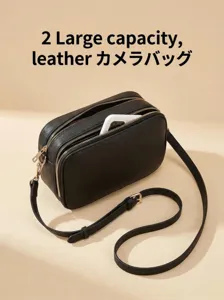 Detalle del bolso de cámara de cuero negro con bolsillos funcionales de doble cremallera.