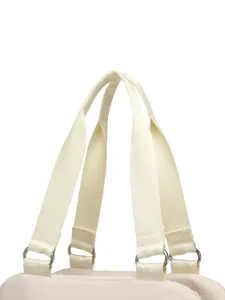 Primer plano de las asas tejidas y anillas metálicas de un bolso deportivo beige impermeable