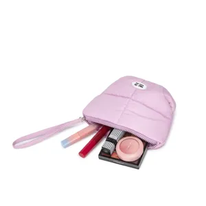 Gedetailleerde weergave van de paarse gewatteerde nylon make-uptas met cosmetica erin.