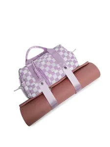 Close-up detail of purple checkered duffel travel bag carrying a rolled pink yoga mat