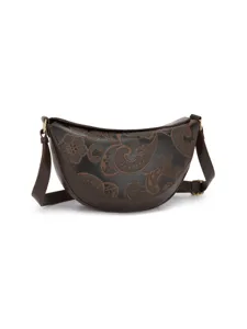 Detalle de cerca de un bolso bandolera retro de media luna con motivos paisley en relieve