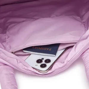 Detailopname van het ritsvak aan de binnenkant van een lichtpaarse gewatteerde tas