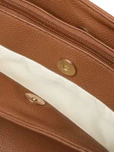 Primer plano del interior del bolso de cuero marrón con cierre magnético y cremallera.