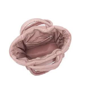 Ruime binnenweergave van een zachte, roze gewatteerde tas met een ritsvak detail