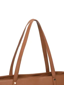 Primer plano de las resistentes correas de cuero marrón de un bolso grande para mujer.