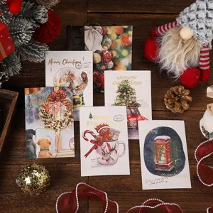 Detail of festive Christmas greeting cards with gold foil lettering on wooden table