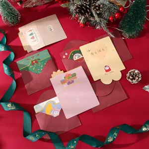 Detailed view of assorted die-cut Christmas greeting cards with red envelopes and festive decor