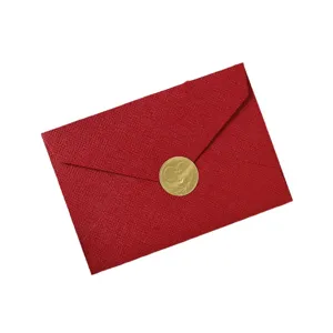 Sobre rojo con textura de lino y sello dorado de corazón para invitaciones elegantes