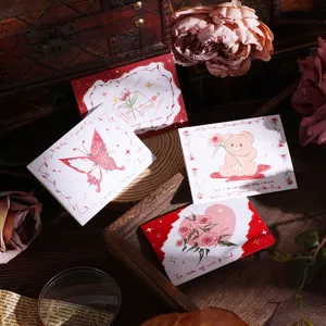 Detail of vintage trifold greeting cards with floral and bear designs in warm light