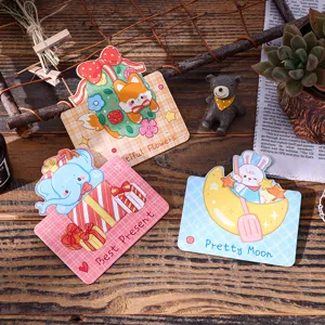 Gedetailleerd overzicht van drie schattige cartoon dieren wenskaarten op een houten tafel