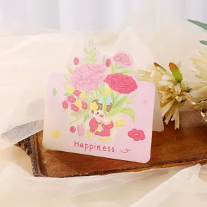 Vista detallada de una linda tarjeta de felicitación rosa con ilustración floral y texto Happiness